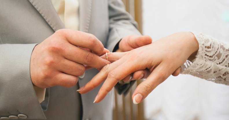 A man and woman exchange rings at a wedding