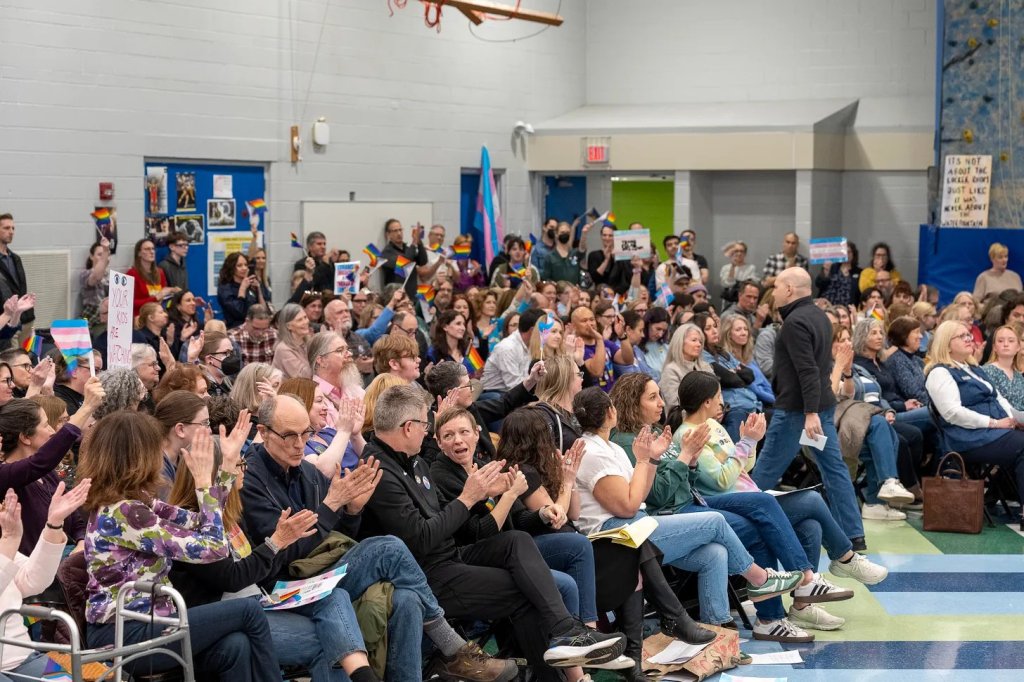 Hundreds of community members and trans-rights supporters applaud and cheer during a Deerfield District 109 board meeting at Caruso Middle School in Deerfield, IL, on April 10, 2025. Photo by Tyler Pasciak LaRiviere for the Chicago Sun-Times.