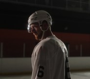 Luke Prokop in ice hockey gear in a dim rink