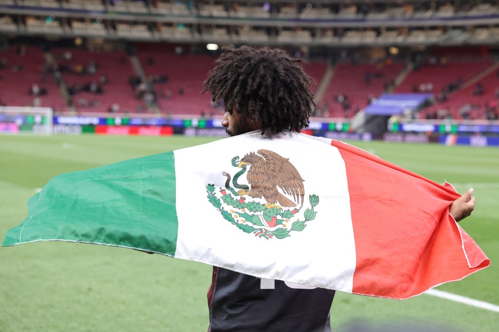 Joseph Athalé with the Mexican flag after the team's defeat in the FIFA World Cup 2026 Qualifying Playoff tournament match