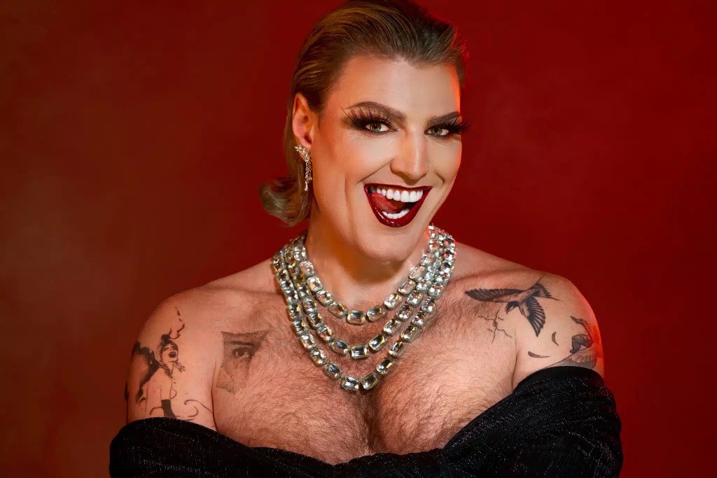 Reuben Kaye: Hard To Swallow: in cabaret jewels with their chest out and three bright necklaces.