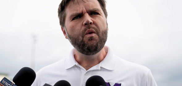 JD Vance, pictured speaking into a set of microphones.