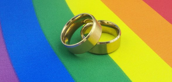wedding rings on pride flag