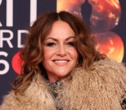 Jaime Winstone smiling at the camera in a fluffy collared coat