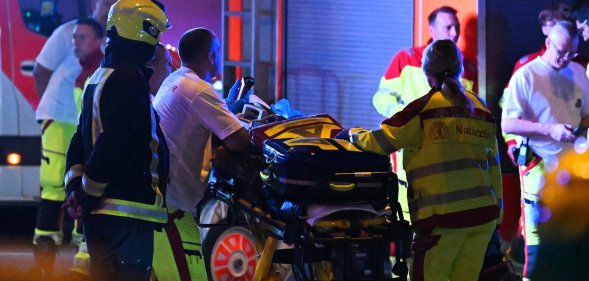 Emergency personnel and police work near the scene where one person was killed and around 15 injured after a car is believed to have hit the crowd on the outskirts of the Christopher Street Day (CSD)