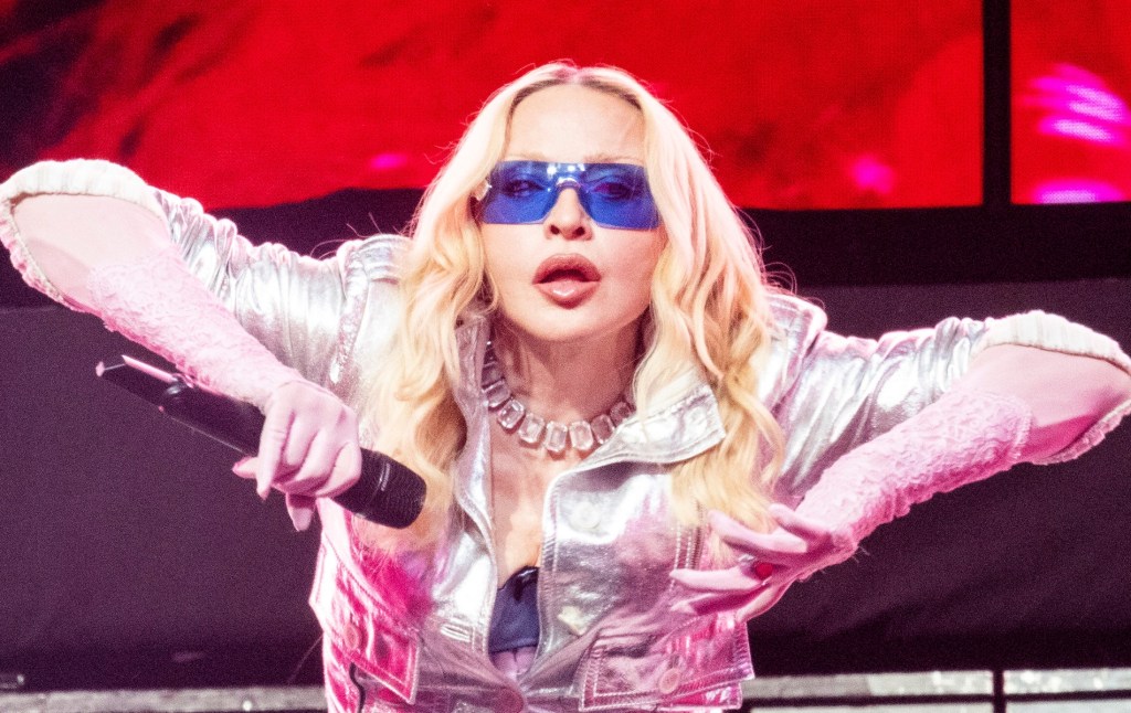 Madonna's Confessions II is out now. Madonna performing on stage in silver jacket and blue glasses
