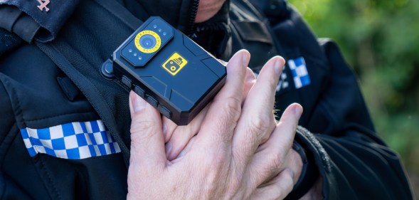 A police man putting on a bodycam