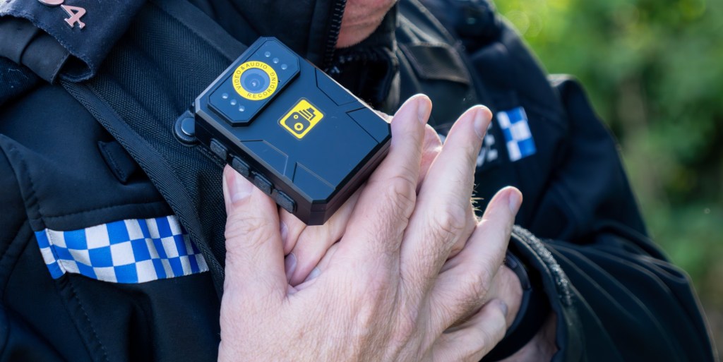 A police man putting on a bodycam