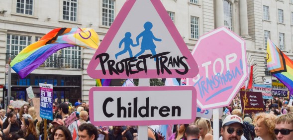 A participant holds a 'Protect Trans Children' placard during London Trans Pride 2025