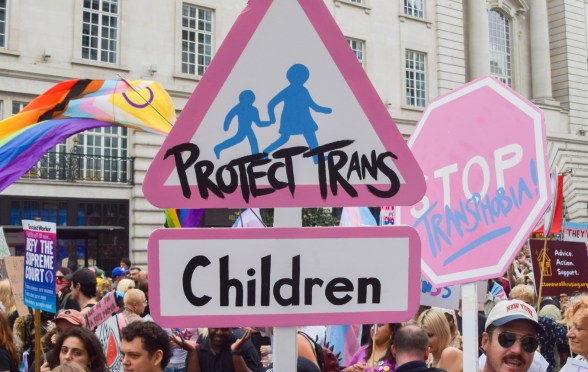 A participant holds a 'Protect Trans Children' placard during London Trans Pride 2025