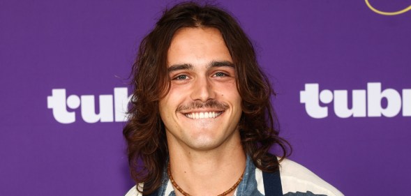 Charlie Gillespie smiling against a purple background