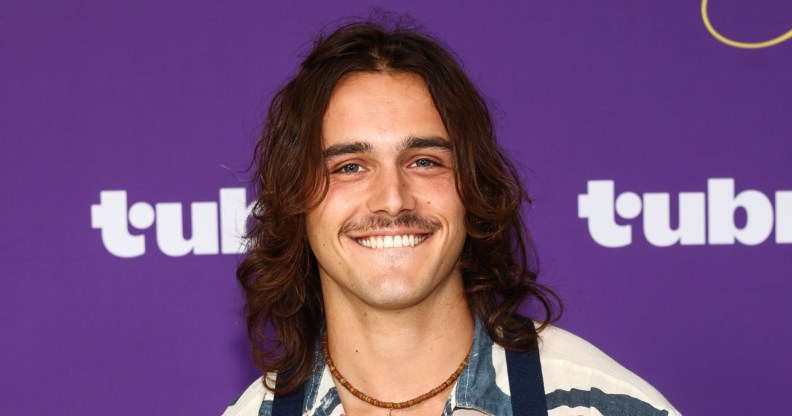 Charlie Gillespie smiling against a purple background