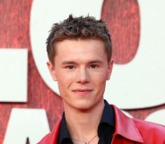 Edvin Ryding on a red carpet, wearing a black shirt and red leather jacket