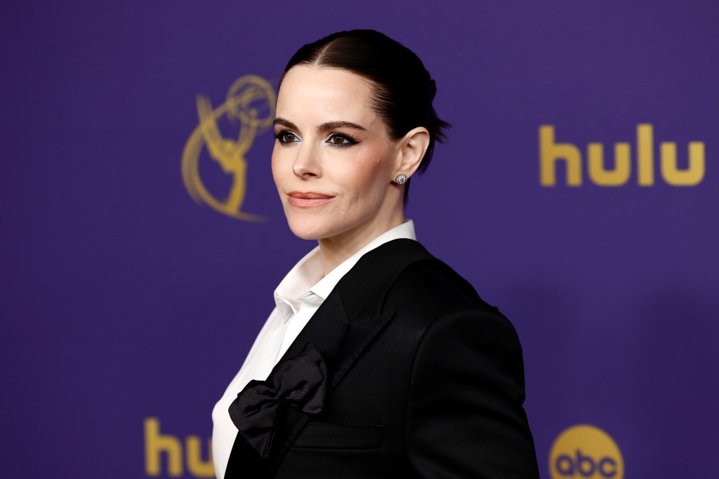 Emily Hampshire attends the 76th Primetime Emmy Awards, she's wearing a white shirt and black suit