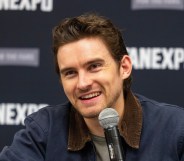 Actor Michael Johnston during the FanExpo Chicago. He's smiling in a dark navy jacket with dark brown cordoroy collar.