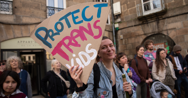 Someone holding a sign reading 'Protect trans kids'