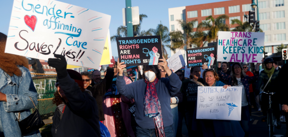 People holding signs in favour of gender-affirming care