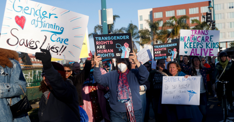 People holding signs in favour of gender-affirming care