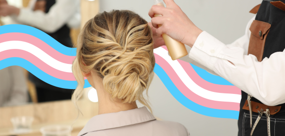 A woman having her hair done at a salon with a trans flag banner behind her.