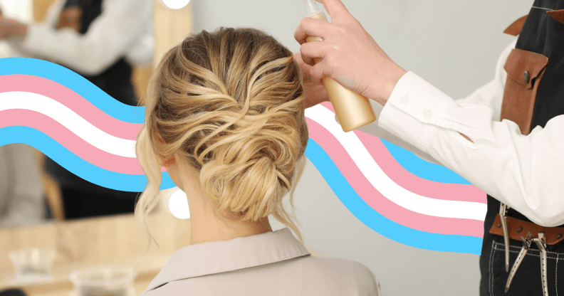 A woman having her hair done at a salon with a trans flag banner behind her.