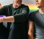 older man with a younger man with rainbow colours behind them