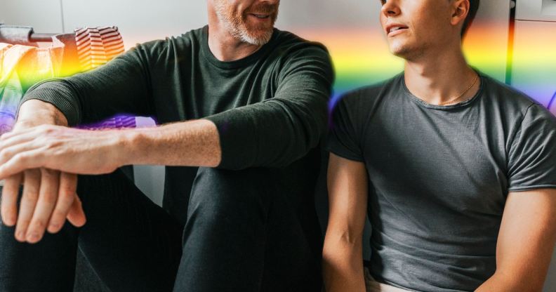 older man with a younger man with rainbow colours behind them