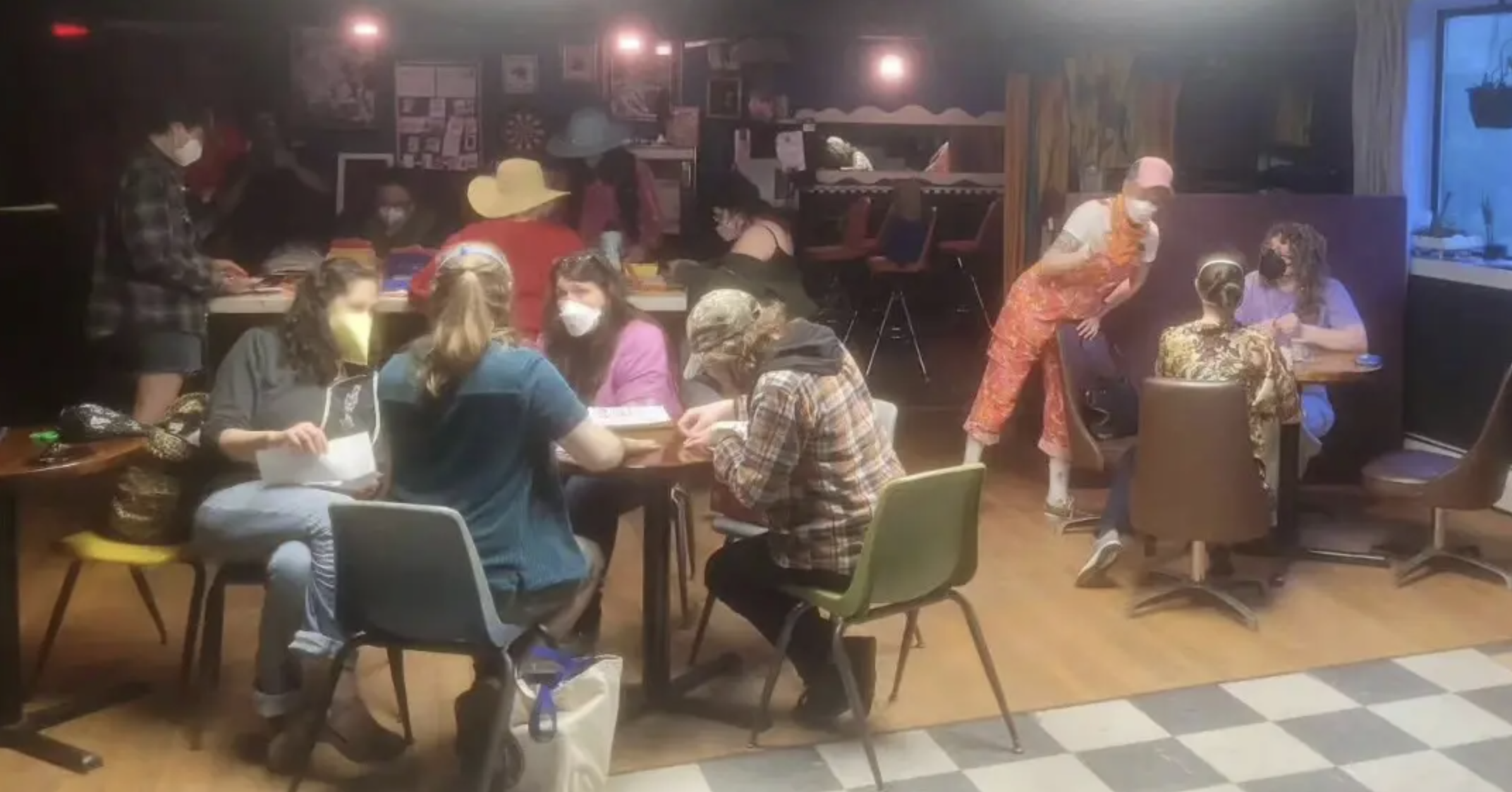 Patrons sitting in the 'Last Ditch Bar' wearing face masks