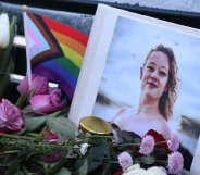 A vigil for Renée Good with a Pride flag and flowers.