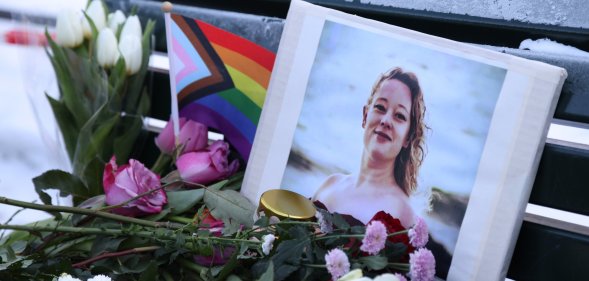 A vigil for Renée Good with a Pride flag and flowers.