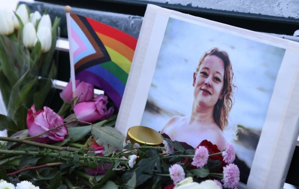 A vigil for Renée Good with a Pride flag and flowers.