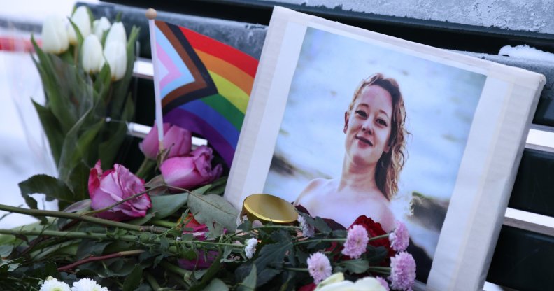 A vigil for Renée Good with a Pride flag and flowers.