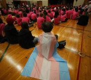 A student wears a trans flag during an assembly