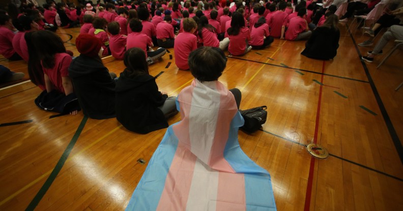 A student wears a trans flag during an assembly