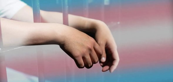 a person in prison with the trans Pride flag colours