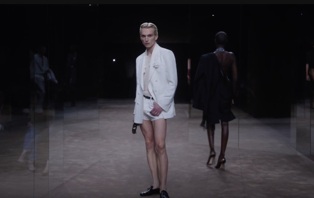 Model wearing an all-white suit with tiny shorts