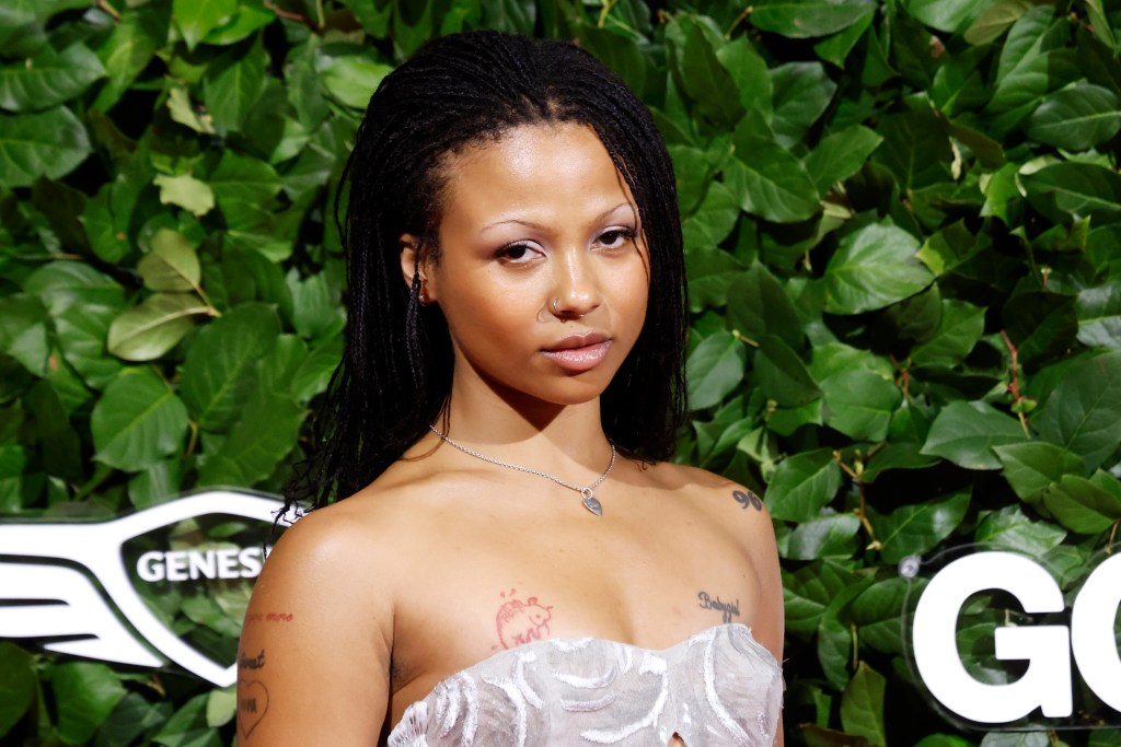 Myha’la headshot on red carpet with green leaves behind her