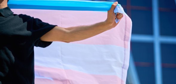 Person holds transgender Pride flag
